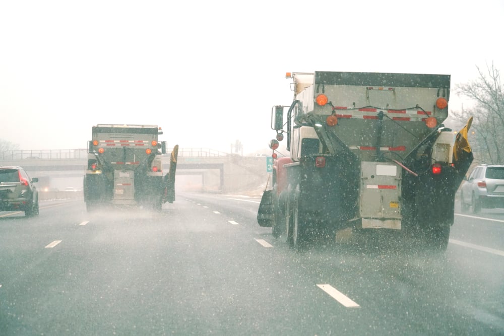 trucks putting salt on an icy road