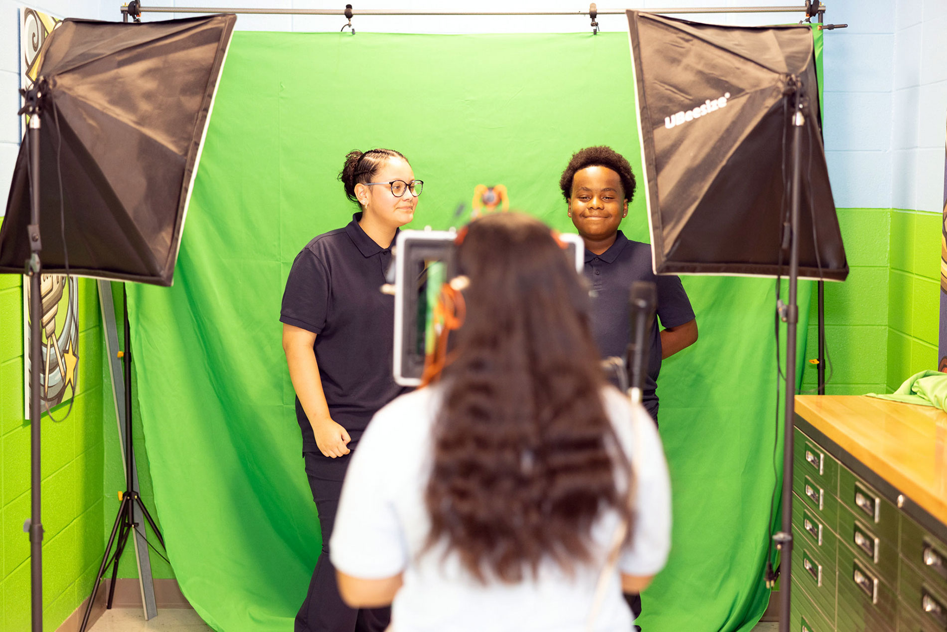 Students filming against a green screen